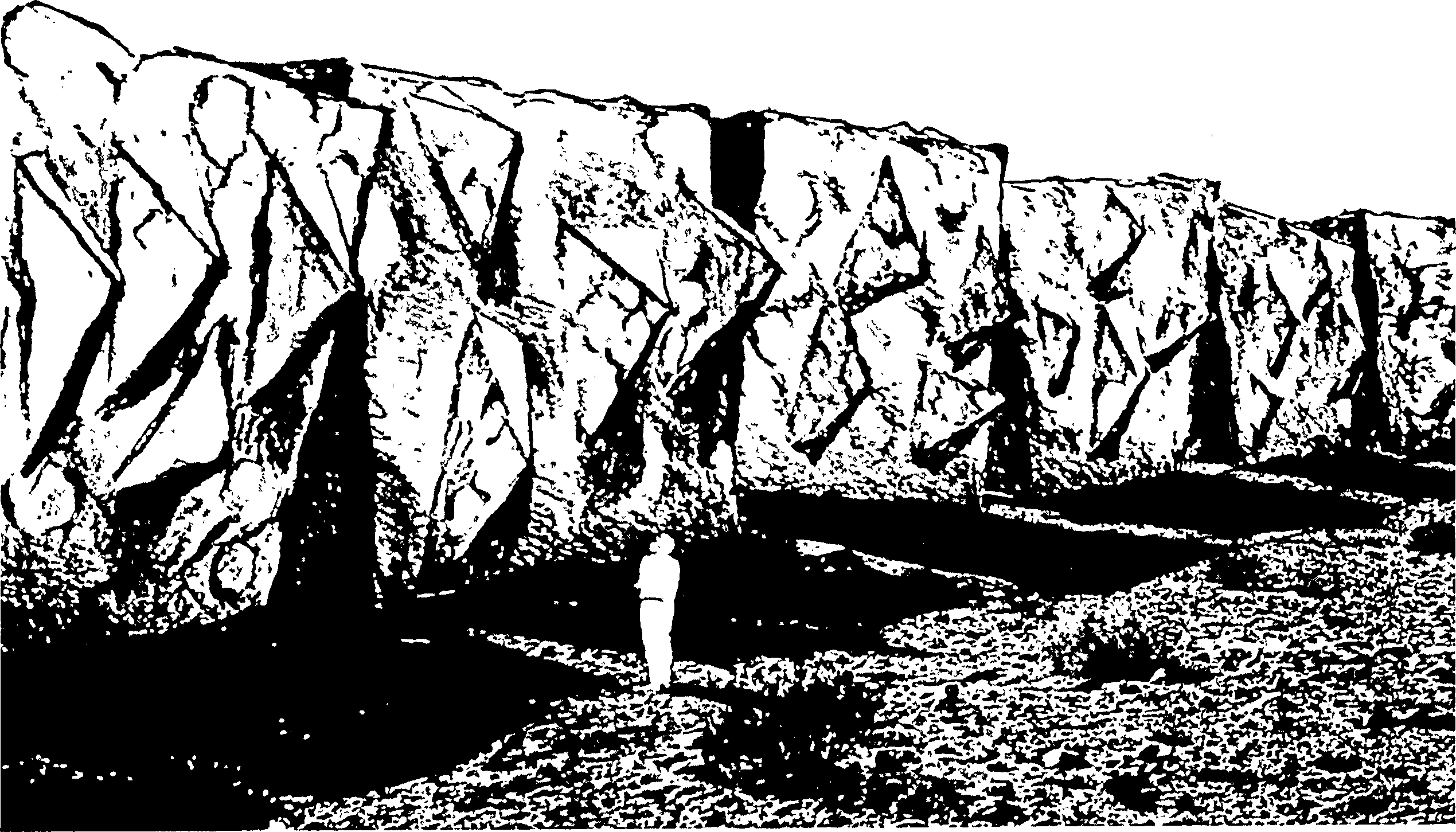 Drawing of a person standing in front of a wall made up of massive stone blocks, the visible sides bearing irregular protrusions
